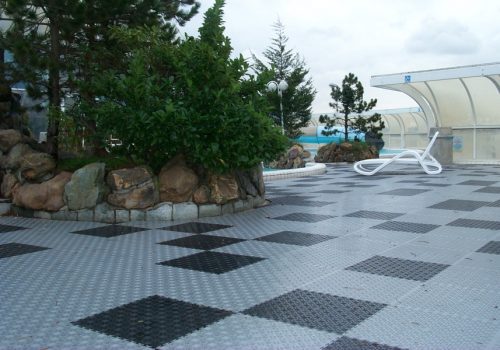 Grey and black open floor tiles around a pool area