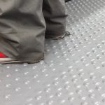 Feet standing on a grey studded Flexi-Tile
