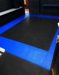 Rugby club changing room with black and blue floor tiles